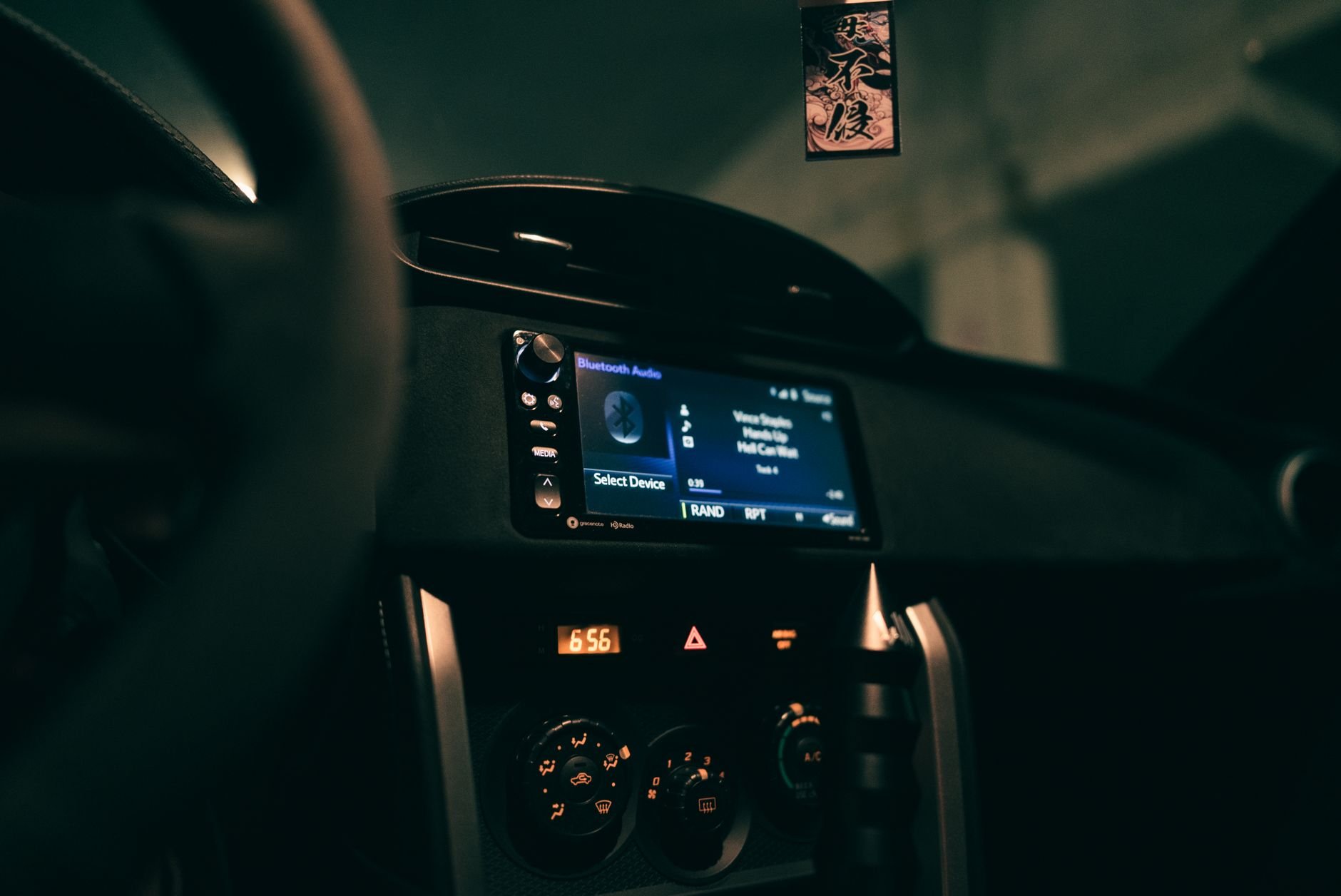 Car dashboard showing an audio system display in a dimly lit interior, focusing on technology.